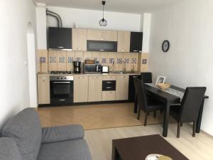 a kitchen with a table and a dining room at Confort Apartment in Mediaş
