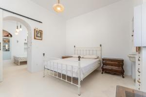 a white bedroom with a bed and a dresser at Old Mansion in Melanes in Mélanes