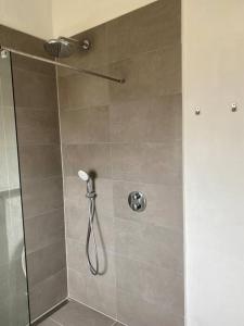 W łazience znajduje się prysznic ze szklanymi drzwiami. w obiekcie Fin ny moderniseret lejlighed i Skagen. w mieście Skagen
