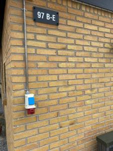 a brick wall with a street sign on it at Fin ny moderniseret lejlighed i Skagen. in Skagen