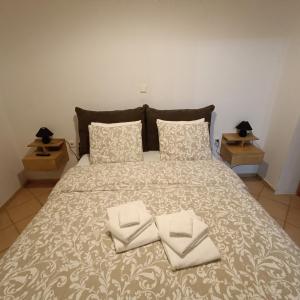 a large bed with two folded towels on it at Baou House 1 in Metsovo