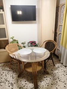 mesa con 2 sillas y TV en la pared en Magnifique Studio non fumeur près de la gare, en Béziers