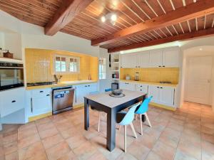 a kitchen with a table and blue chairs in it at Villa Pio in Roquebrune-sur-Argens
