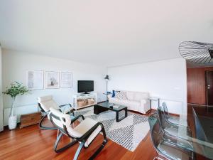 a living room with a couch and a table and chairs at Just Like Home - Oceanside Walk in Caminha