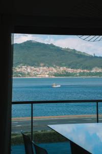 a view of a boat in the water from a window at Just Like Home - Oceanside Walk in Caminha