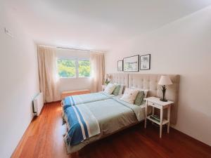 a white bedroom with a bed and a window at Just Like Home - Oceanside Walk in Caminha