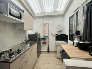 uma cozinha com um lavatório e um fogão forno superior em HERMOSO APTO EN LAURELES em Medellín