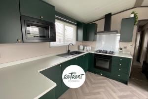 a kitchen with green cabinets and a sink at ReTreat Breaks - 47 Park Lane in Patrington