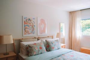 a bedroom with a bed with two pictures on the wall at Just Like Home - Oceanside Walk in Caminha
