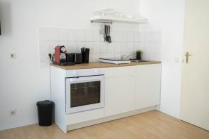 a kitchen with white cabinets and a counter top at Stadtoase Design Wohnung in der Altstadt in Koblenz