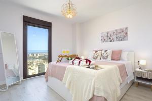 biała sypialnia z dużym łóżkiem i oknem w obiekcie -MalagaSunApts-SkyGarden Teatinos Pool Playground w Maladze +29 zdjęć