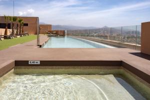 uma piscina no topo de um edifício em -MalagaSunApts-SkyGarden Teatinos Pool Playground em Málaga