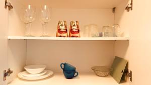 a shelf with wine glasses and other items on it at C-House Inchiriaza Apartament 2 Camere in Regim Hotelier in Râmnicu Vâlcea