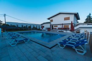 a swimming pool with lounge chairs next to a house at Quinta da Costinha in Alijó