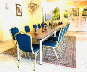 a dining room table with chairs and a long table at Pension Waldau in Kassel