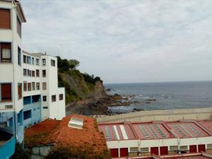 balkon z widokiem na budynek i ocean w obiekcie FrantzunatxakVistas al mar EBI10012 w mieście Bermeo