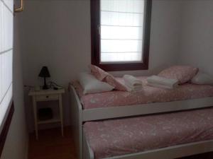 een kleine slaapkamer met een bed en een raam bij FrantzunatxakVistas al mar EBI10012 in Bermeo