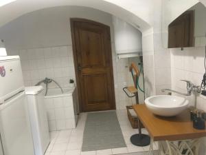 ein Bad mit einem Waschbecken, einem WC und einer Tür in der Unterkunft Apartmán Pod Synagogou in Humpolec