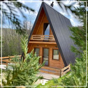 Cabaña de madera con techo negro en Villa Family en Orllan