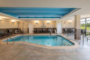 uma grande piscina num quarto de hotel com mesas e cadeiras em Fairfield Inn & Suites by Marriott Little Rock Airport em Little Rock