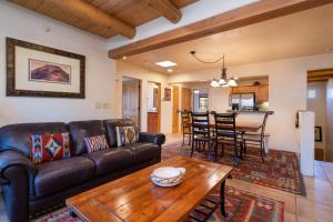 ein Wohnzimmer mit einer Ledercouch und einem Tisch in der Unterkunft El Corazon 12 in Santa Fe