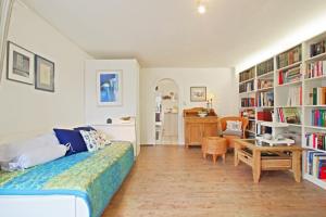 a bedroom with a bed and a desk and book shelves at Private Apartment in Hannover