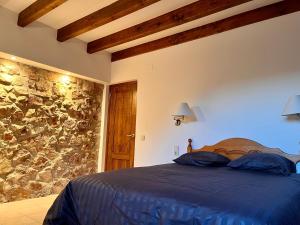 ein Schlafzimmer mit einem Bett und einer Steinmauer in der Unterkunft Casa Margherita in Alquézar