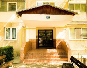 uma porta da frente de uma casa com escadas em C-House Inchiriaza Apartament 2 Camere in Regim Hotelier em Râmnicu Vâlcea