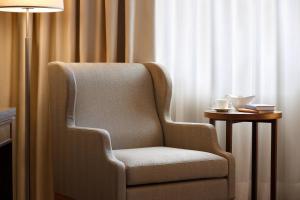 a chair in a room with a lamp and a side table at Sheraton Lake Como Hotel in Como