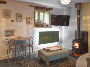 a living room with a fireplace and a stove at Ty Capel in Eglwys-Fâch