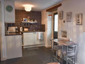 a kitchen with a counter and a table and chairs at Ty Capel in Eglwys-Fâch