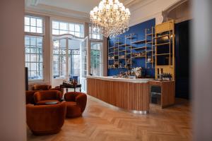 a room with a bar with chairs and a chandelier at MAISON RENARD in Béthune