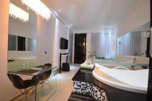 VERT MOTEL MOSSORO في موسورو: حمام كبير مع حوض كبير وغرفة معيشة