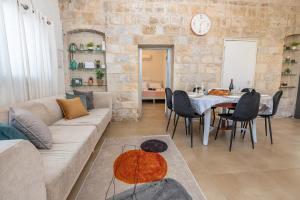 uma sala de estar com um sofá e uma mesa com cadeiras em Nof Marom - the Home in the Old City נוף מרום - הבית בעתיקה em Safed