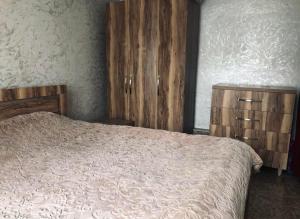 sypialnia z łóżkiem i 2 drewnianymi szafkami w obiekcie Villa Lizzy w mieście Batumi