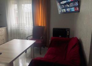 uma sala de estar com uma mesa e uma cadeira vermelha em Villa Lizzy em Batumi