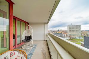 a balcony with a chair and a view of a city at Private Apartment in Hannover