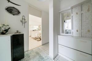 a kitchen with white cabinets and a large mirror at Private Apartment in Hannover