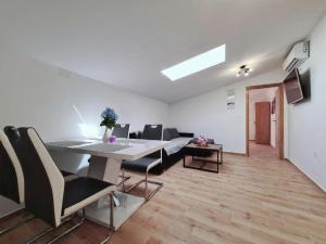 a living room with a dining room table and chairs at Apartments Beleca in Biograd na Moru