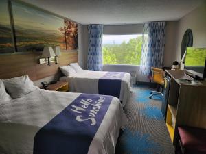 ein Hotelzimmer mit 2 Betten und einem TV in der Unterkunft Days Inn by Wyndham Dahlonega University Area in Dahlonega