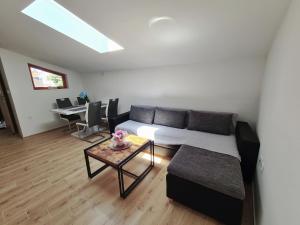ein Wohnzimmer mit einem Sofa und einem Tisch in der Unterkunft Apartments Beleca in Biograd na Moru