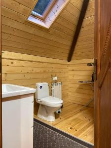 Un baño de madera con inodoro y lavabo. en Sweet Home, en Krasnyy