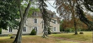 a large white house with trees in front of it at Domaine et Manoir du Picaud in Monestier