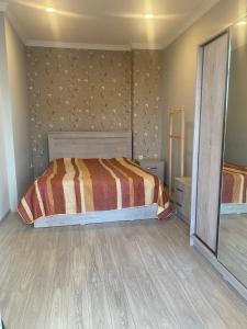 um quarto com uma cama e um espelho em Black See Apartment em Kobuleti
