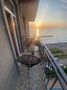 uma varanda com uma mesa e vista para o oceano em Black See Apartment em Kobuleti