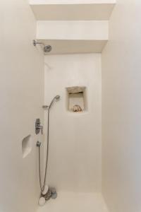 a white bathroom with a shower with a drain at Old Mansion in Melanes in Mélanes