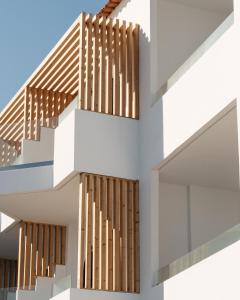 a facade of a white building with wooden stairs at Petradi Beach Lounge Hotel in Rethymno