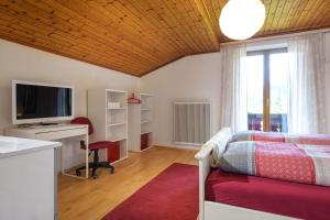 Schlafzimmer mit einem Bett, einem Schreibtisch und einem TV in der Unterkunft Haus Knapp Apartment in Dorfgastein