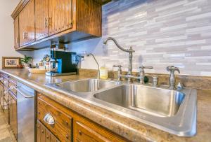 a kitchen with a stainless steel sink and wooden cabinets at Cottage in the City - Historic Charm, Modern Touch in Saint Paul