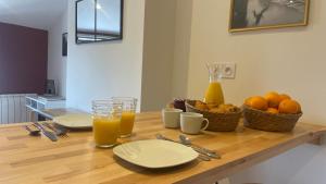 une table avec deux assiettes et deux verres de jus d'orange dans l'établissement Le TerraCotta - Appartement tout équipé à Niort, à Niort